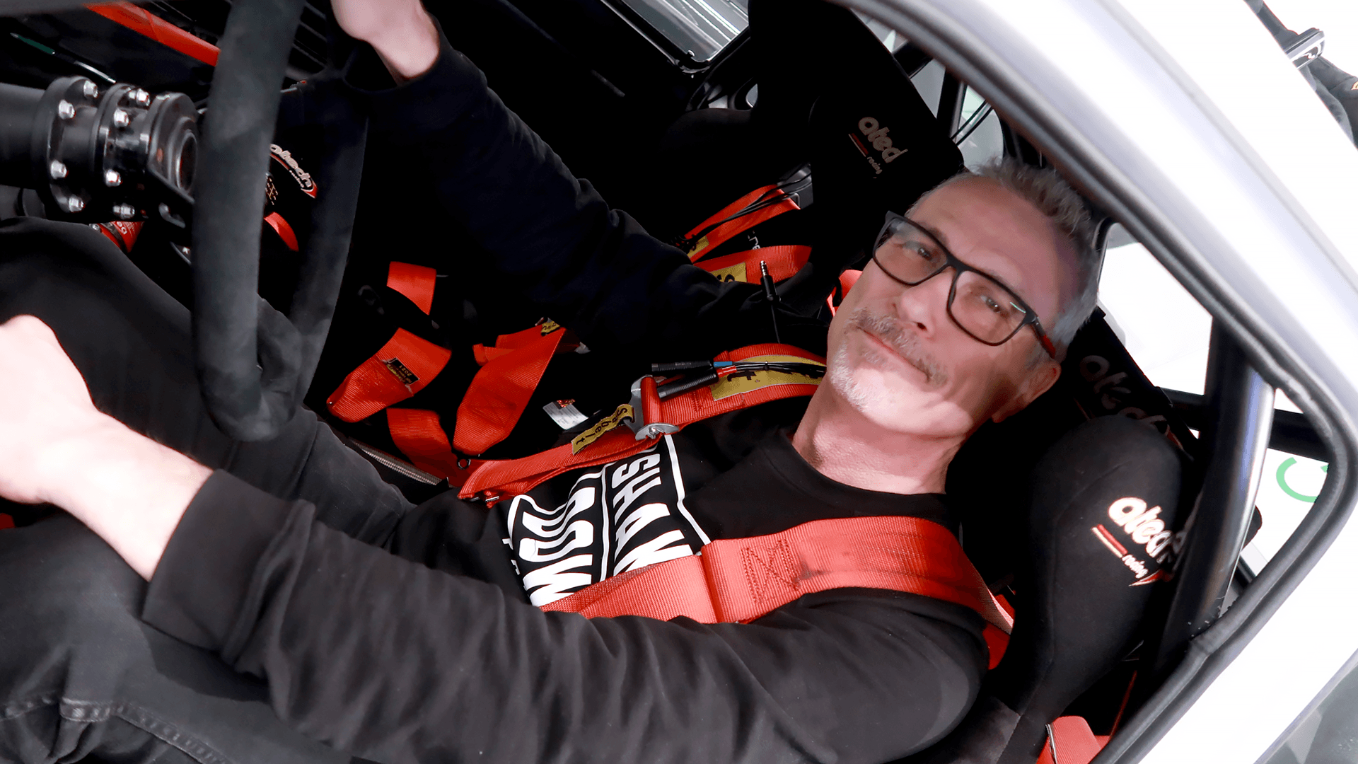 Jouko Neuvonen poseeraa BDA Escort -ralliautonsa ohjauspyörän takana.