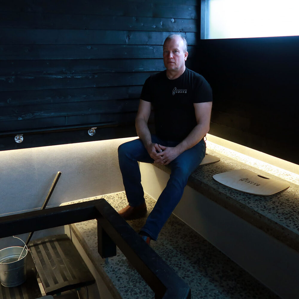 Kankaan saunan yrittäjä Petri Pietikäinen istuu saunan kivisillä lauteilla.